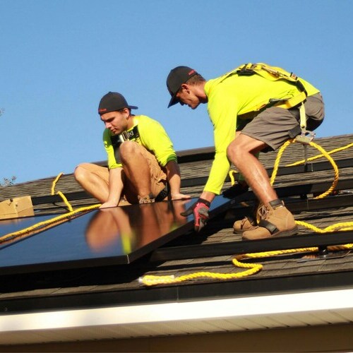 Roofers install roof and solar panels.