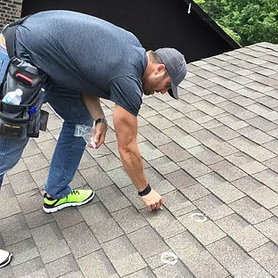 A Roofer Uses Chalk to Mark Roof Damage.
