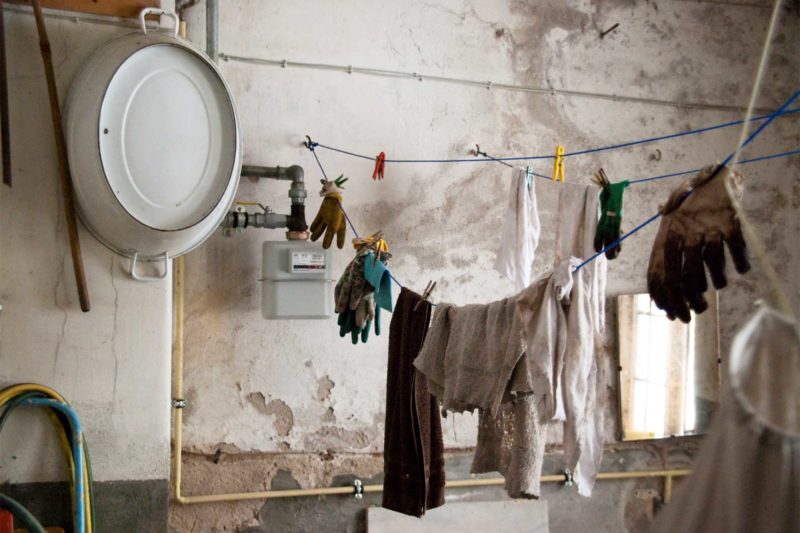 Water Damaged Room With Clothes Hanging From Line.